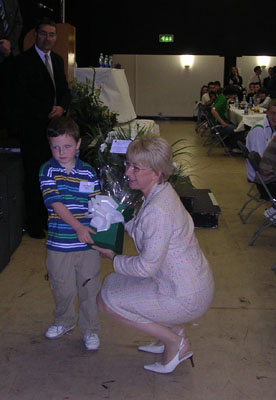 Mary Hanafin receiving a flower bouquet from 5-year old Shane Melaugh at the Glorney and Faber Cups